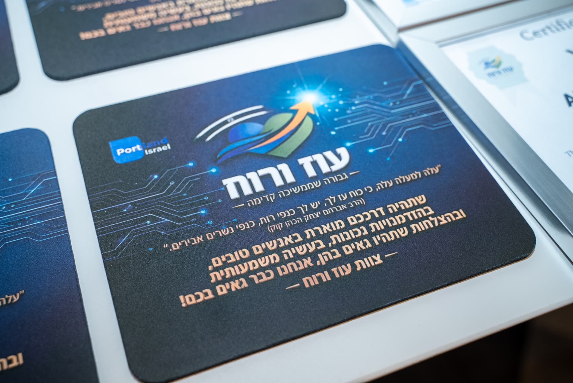 פד מעוצב עם לוגו עוז ורוח לצד תעודות ממוסגרות