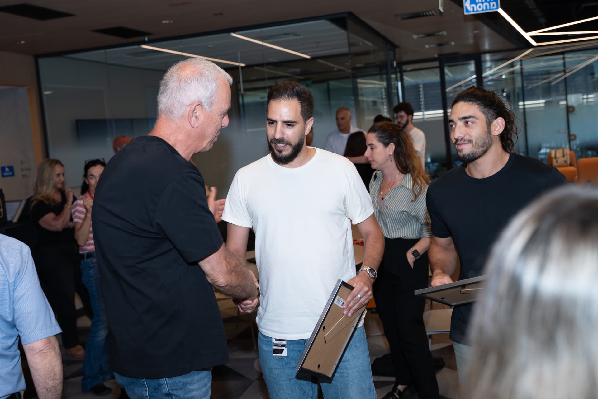 לחיצת יד עם בוגר המחזיק תעודה ממוסגרת